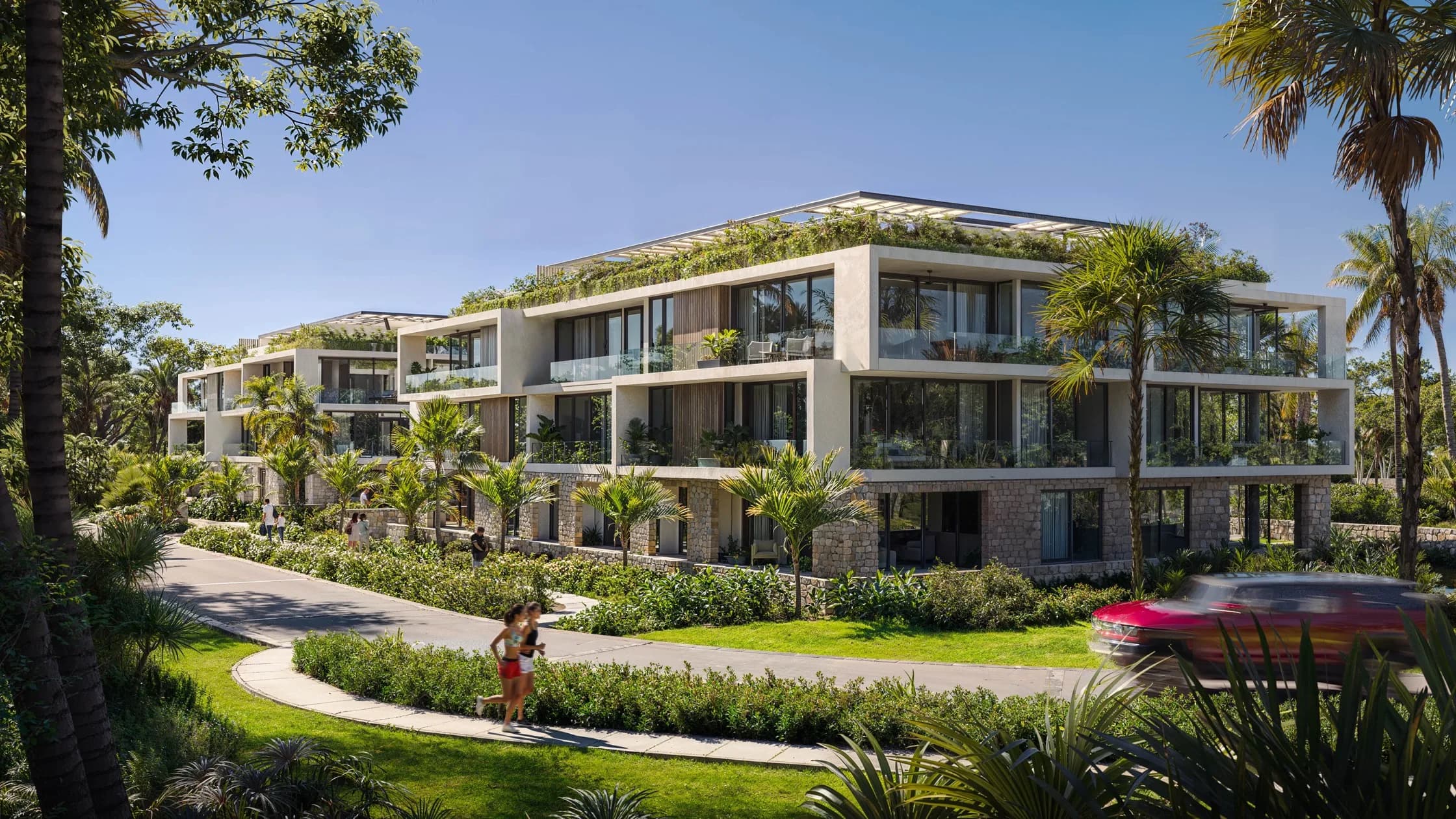 Render de edificios de tres niveles con azoteas verdes entre palmeras y jardines en Bakabá Playacar
