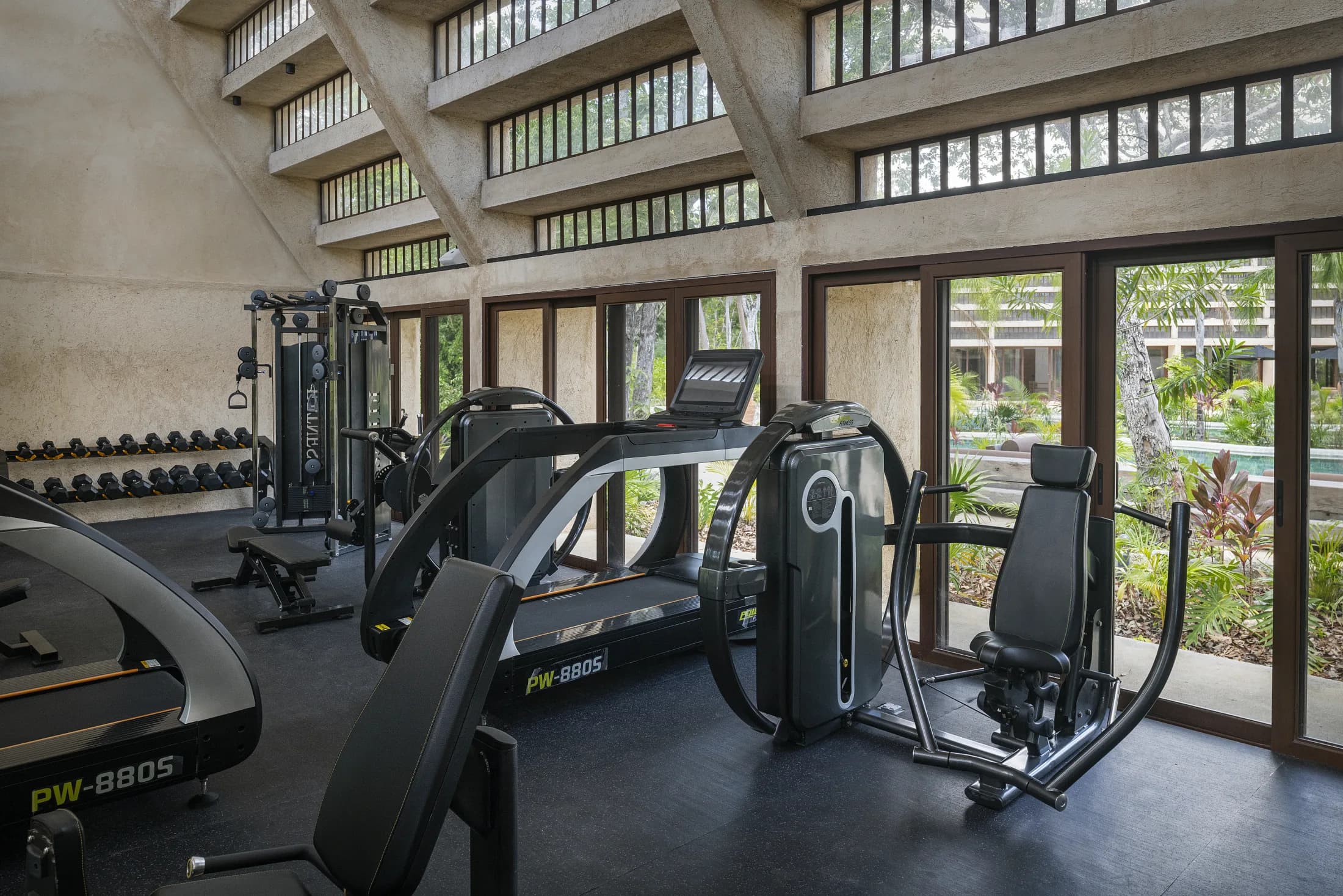 Gimnasio con ventanales hacia el jardín