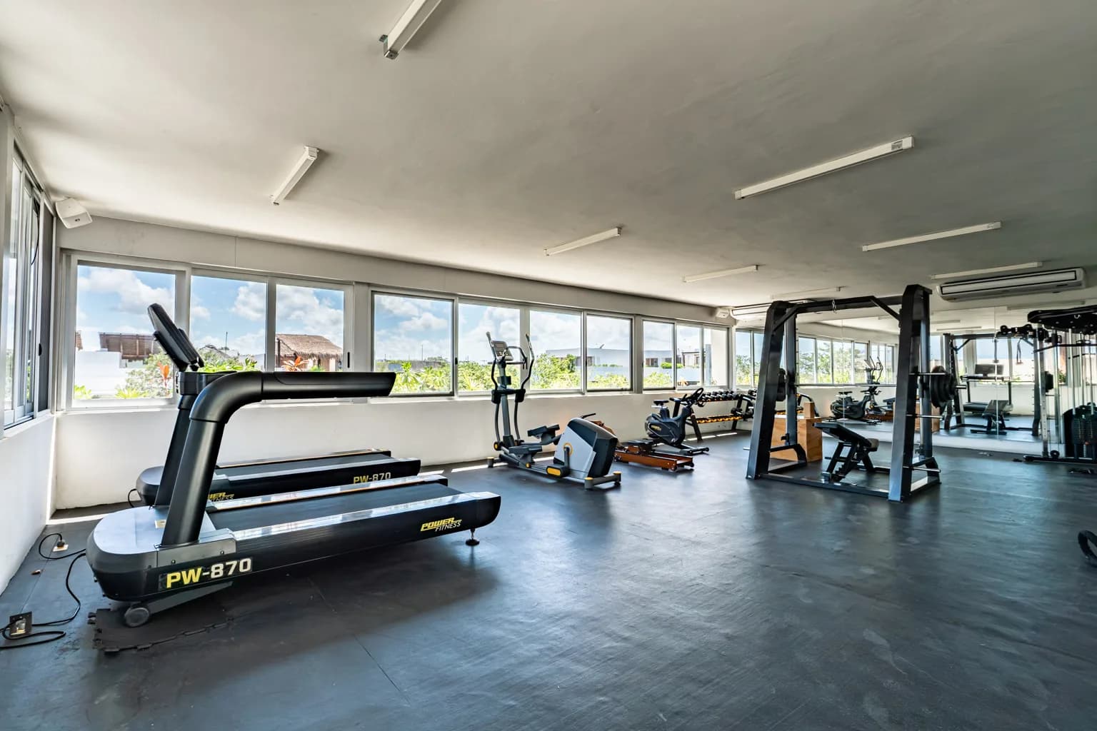 Gimnasio equipado frente a ventanales