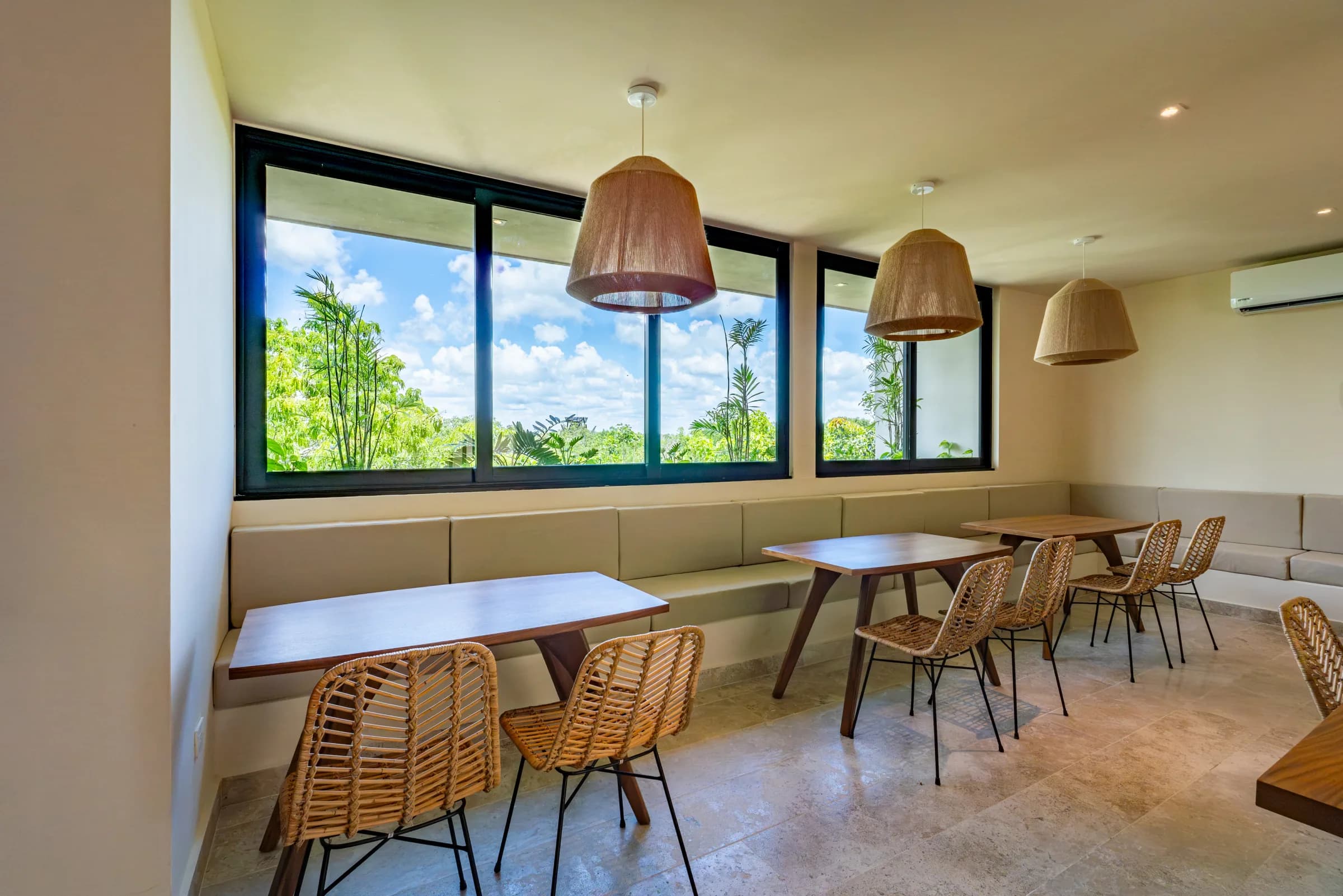 Restaurante de Peregrina con mesas de madera y sillas de ratán