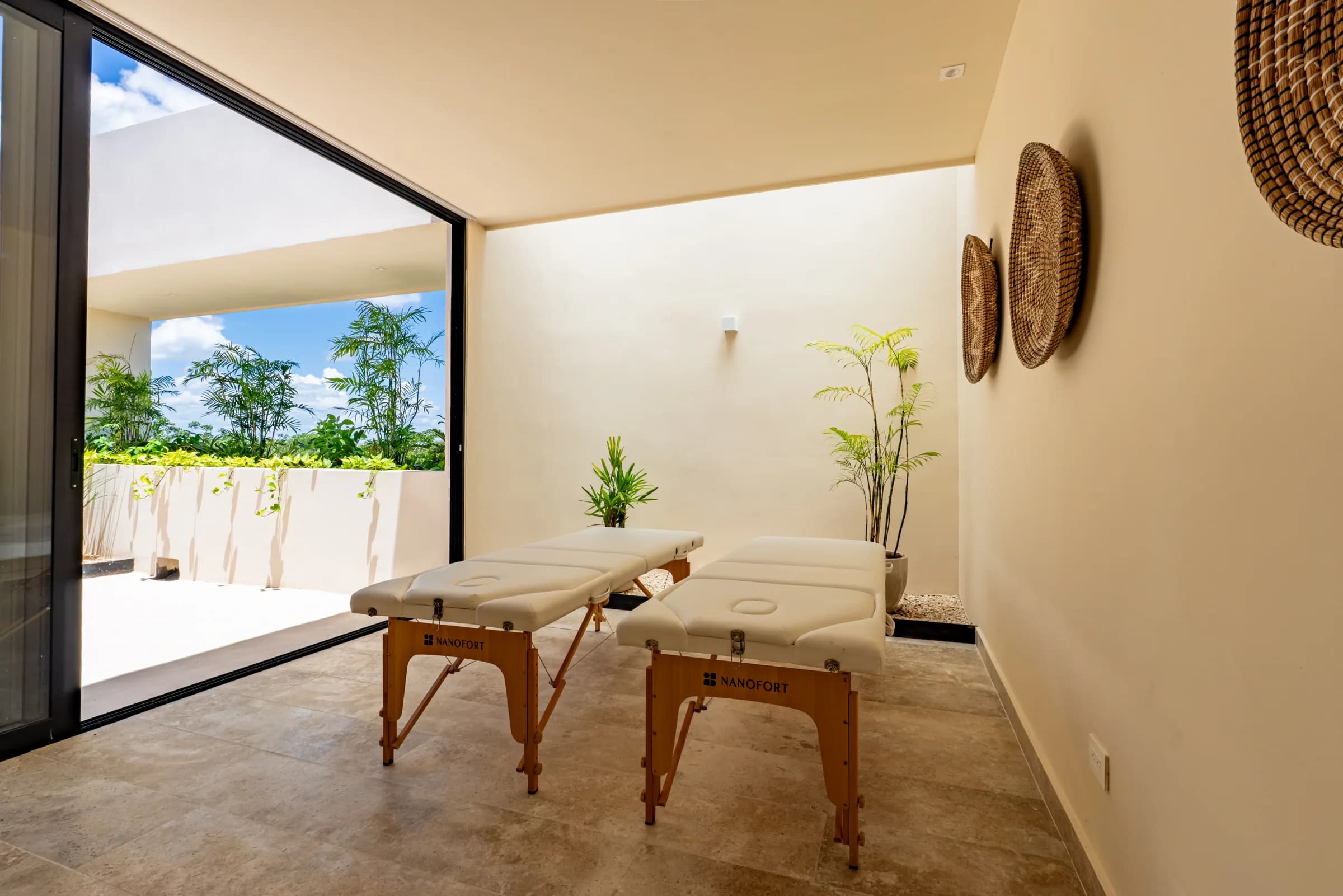 Cabina de spa con dos camillas de masaje y salida a una terraza